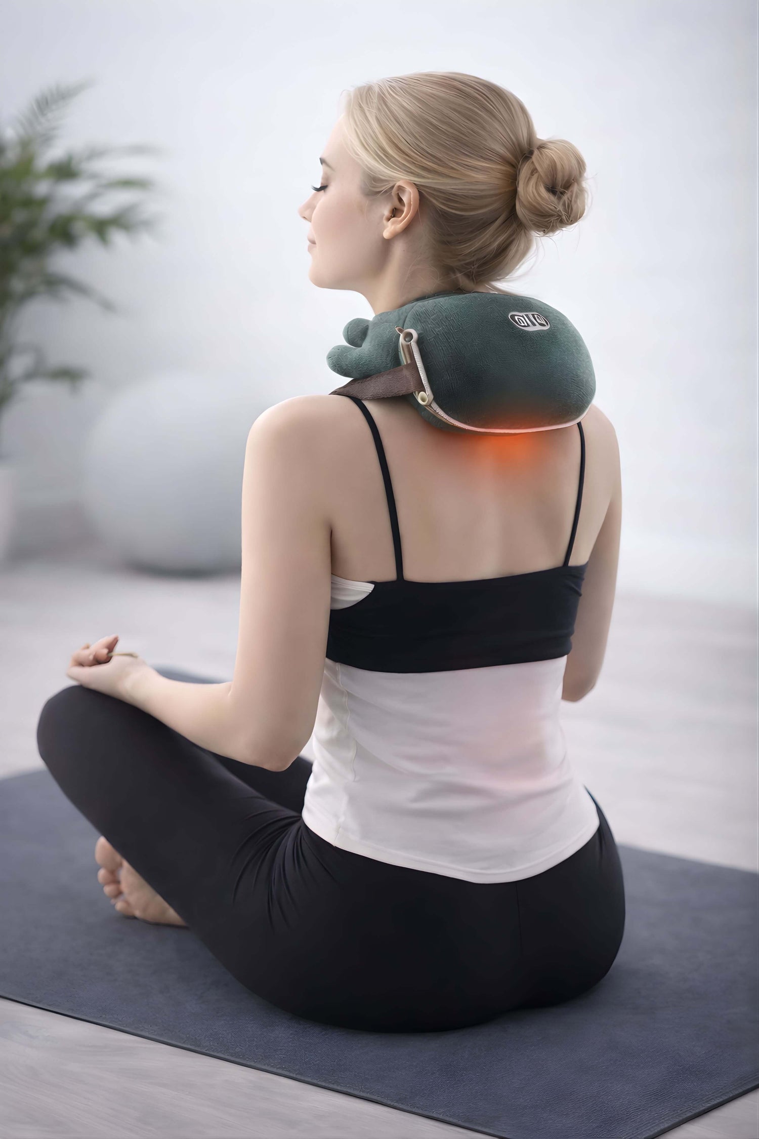 Woman using a neck and shoulder massager in a home setting