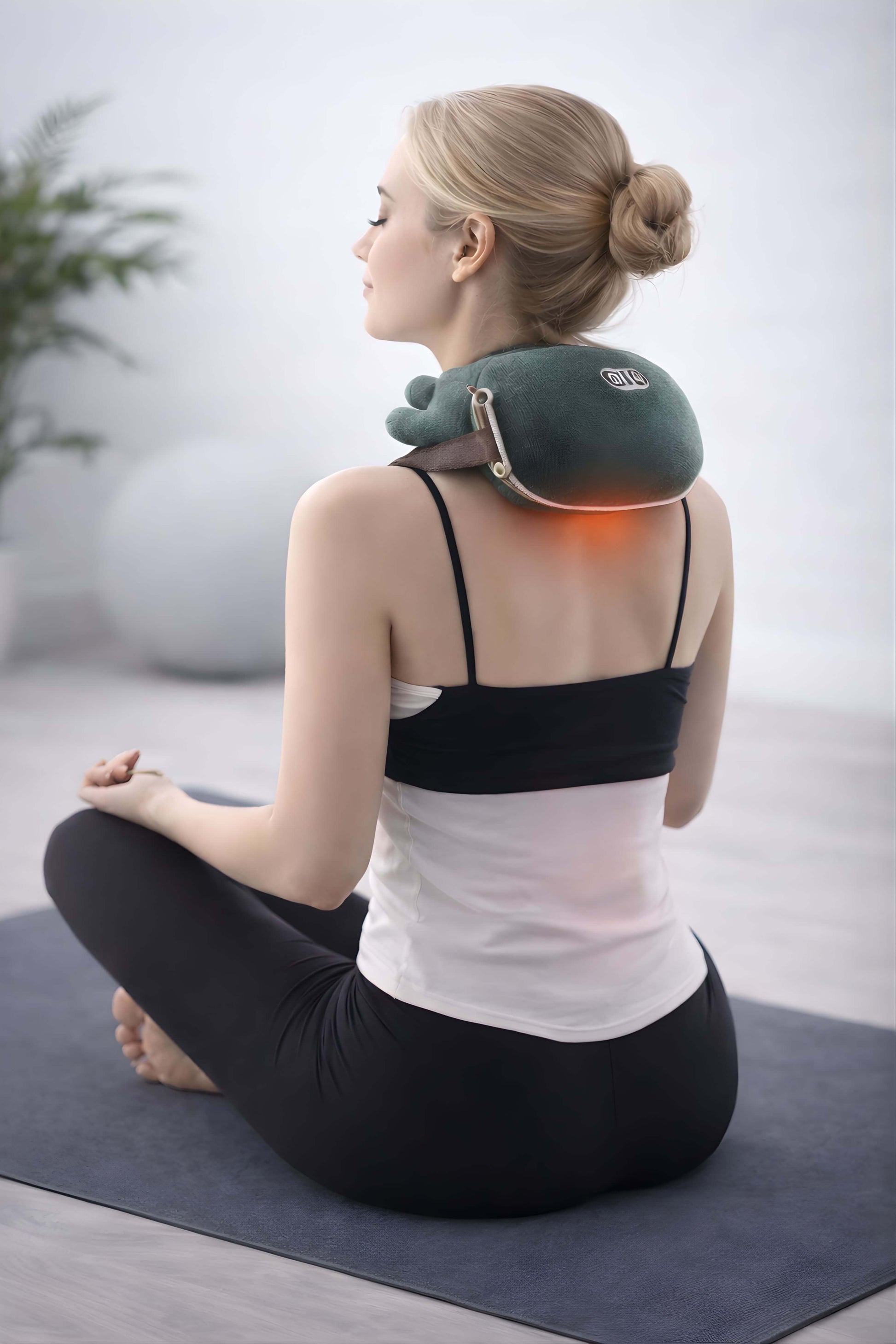 Woman using a neck and shoulder massager in a home setting